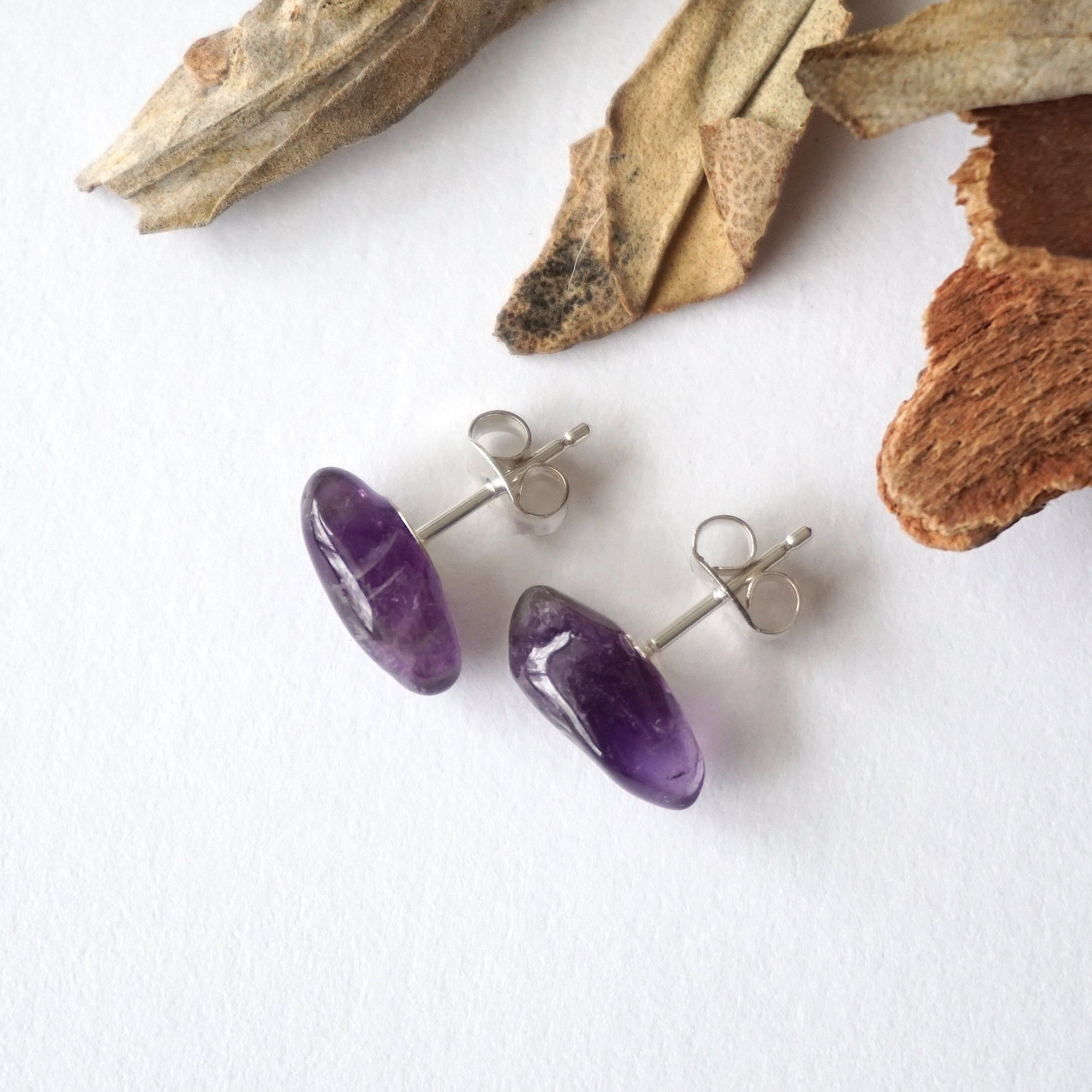 Top view of amethyst stud earrings, natural dark amethyst stones and sterling silver posts