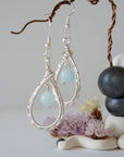 Side angle of aquamarine earrings, showing detailed wire wrapping and genuine gemstone, soft silver finish