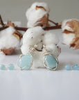 Two aquamarine jewelry sets showing natural variation in aquamarine's color, size, and shape, wire wrapped pendant and stud earrings, Designs by Nature Gems