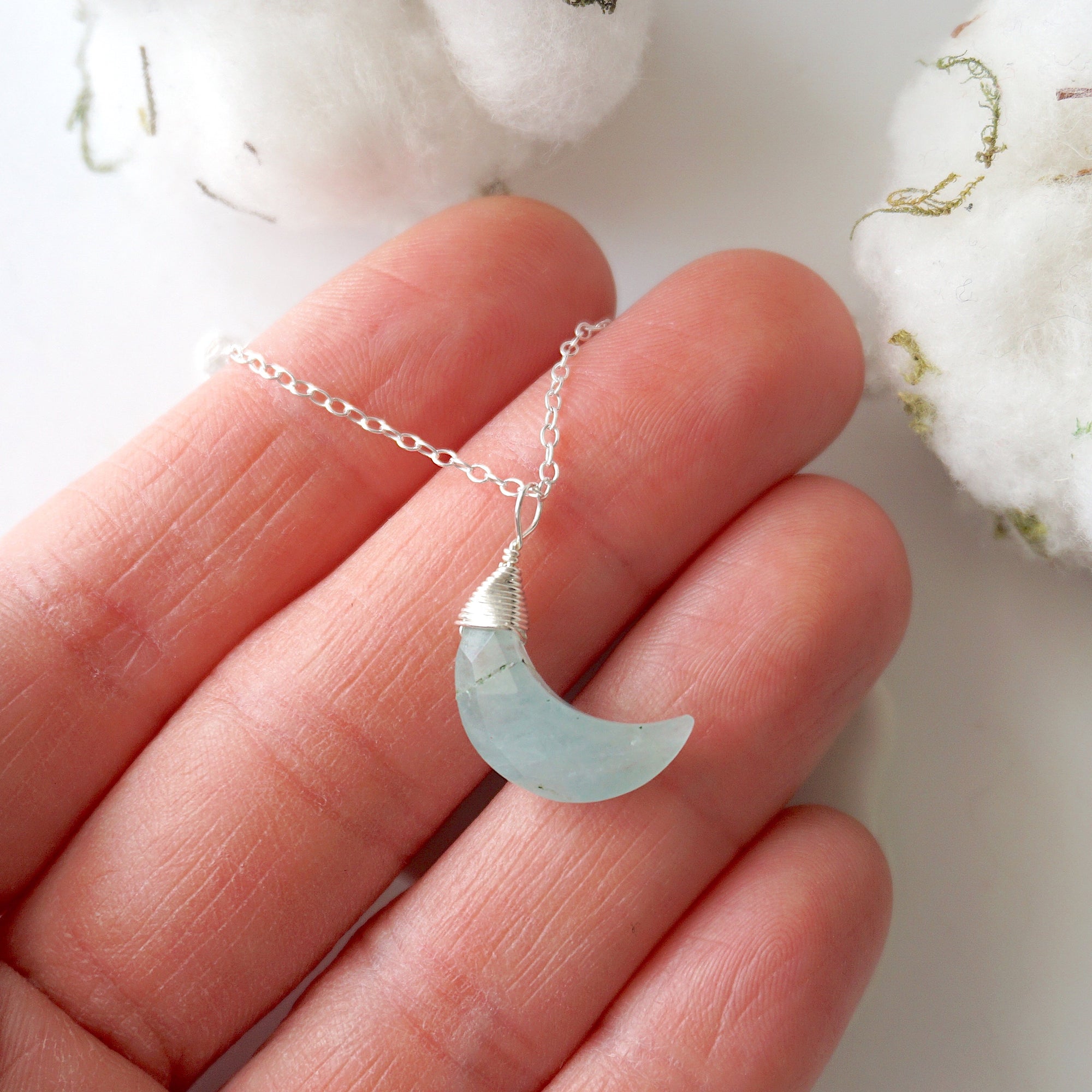 Aquamarine moon necklace in hand for size reference, genuine faceted moon, sterling silver wire wrapping