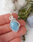 Aquamarine necklace in hand for size reference, artisan wire wrapped, March birthstone jewelry