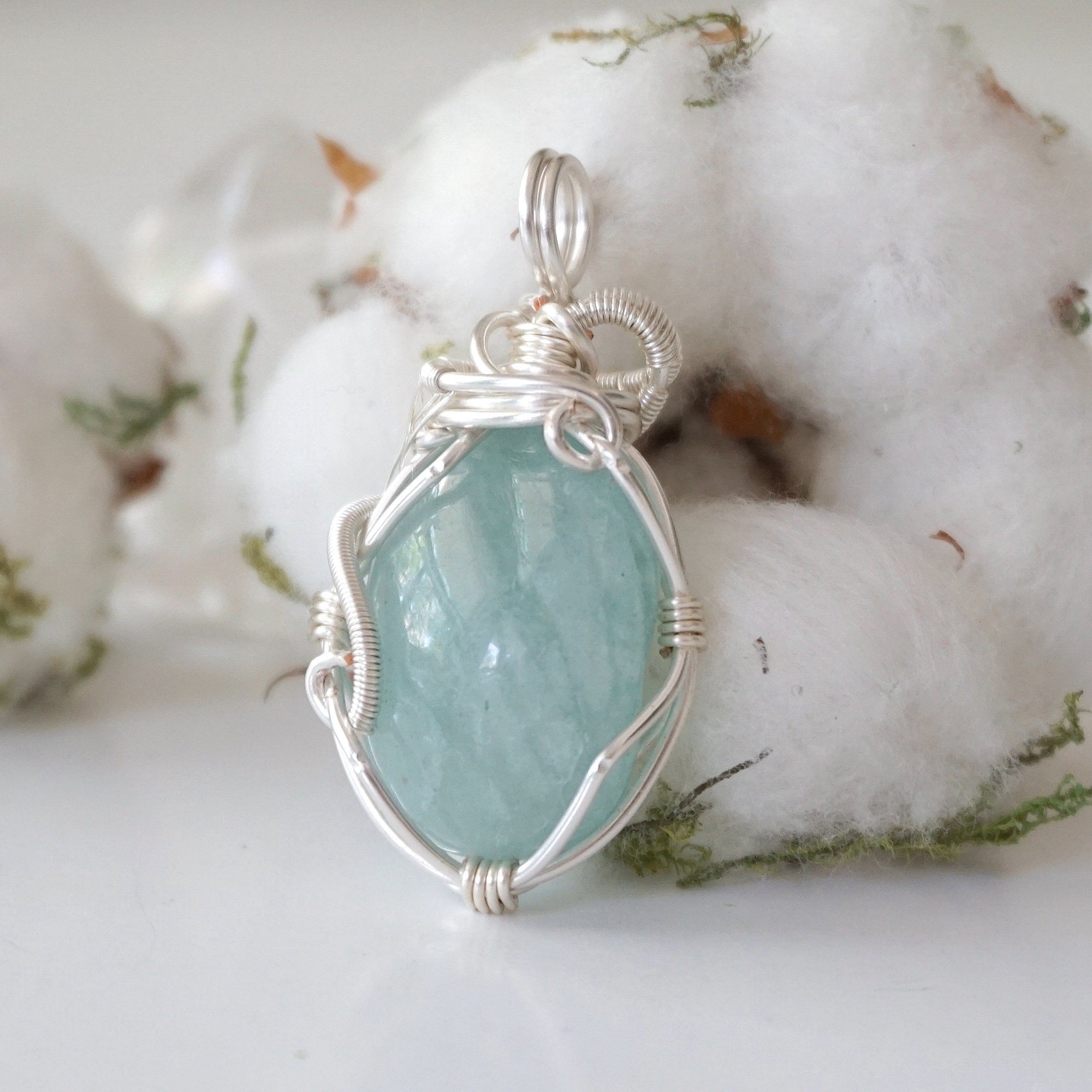 Back angle of aquamarine pendant, highlighting wire wrapped setting and natural stone texture