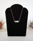 Aquamarine and freshwater pearl bar necklace in 925 sterling silver on jewelry display, front view