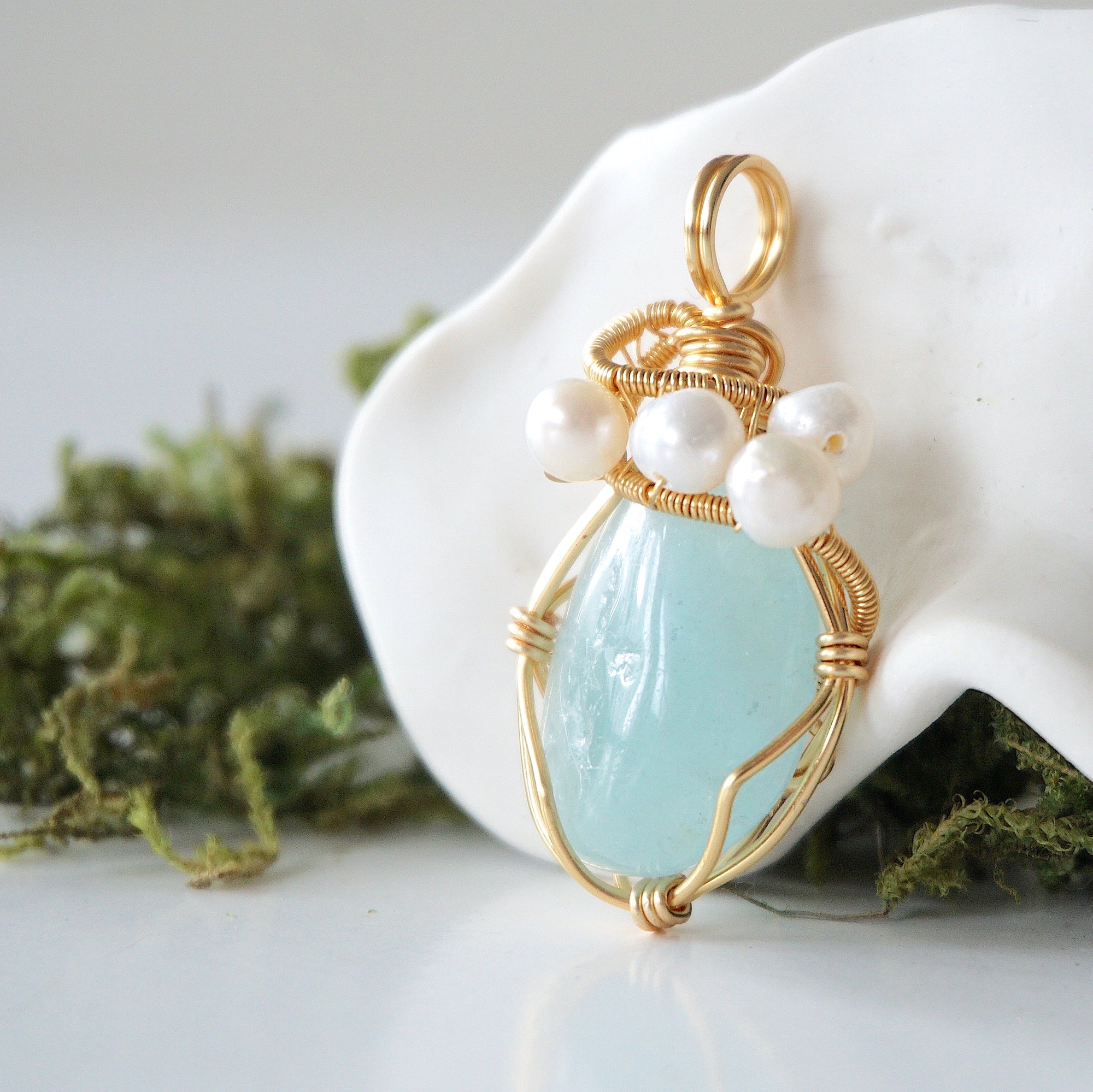 Side angle detail of aquamarine and freshwater pearl pendant, gold wire wrapped, ethical artisan necklace