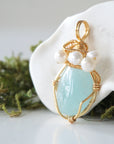 Side angle detail of aquamarine and freshwater pearl pendant, gold wire wrapped, ethical artisan necklace