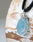 Left side view of raw aquamarine pendant showing detailed artisan wire wrapping in sterling silver, men's design