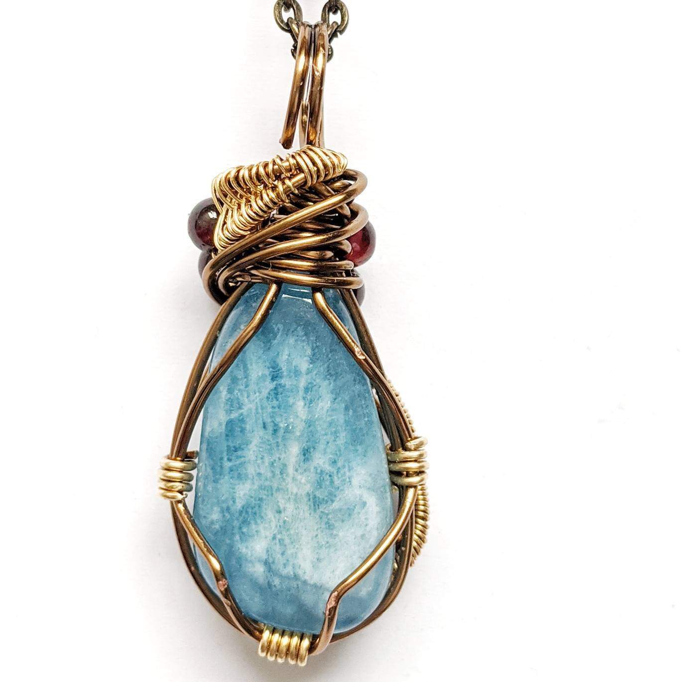 Back angle view of an aquamarine pendant necklace showing the wire wrapped design in antique bronze copper and brass