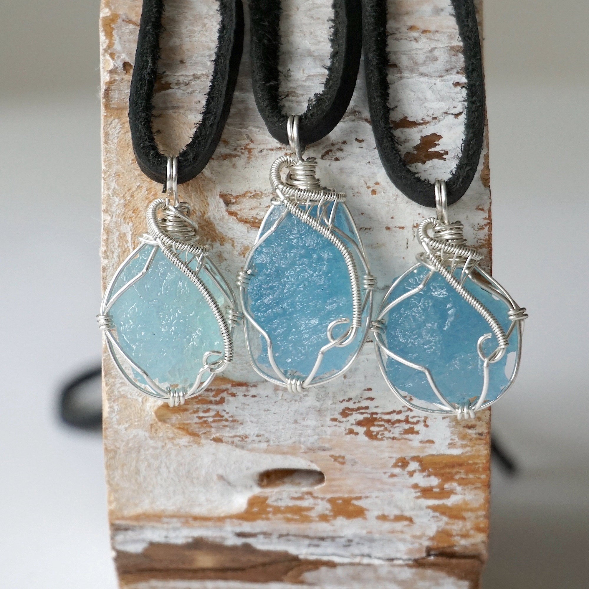 Three raw aquamarine pendants showing natural variation in size, shape, and blue color, Designs by Nature Gems, men's collection