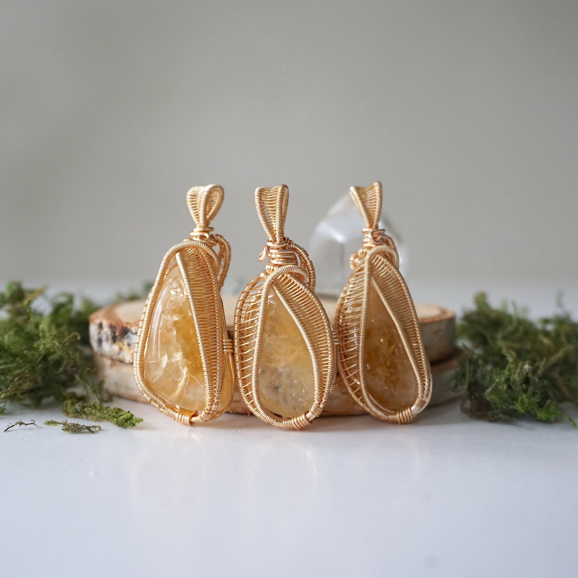 Three citrine necklaces gold wire wrapped showing polished stone size shape and color variation November birthstone options
