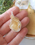 Raw citrine necklace size comparison in hand showing pendant dimensions - handcrafted silver gold wire wrapped crystal jewelry