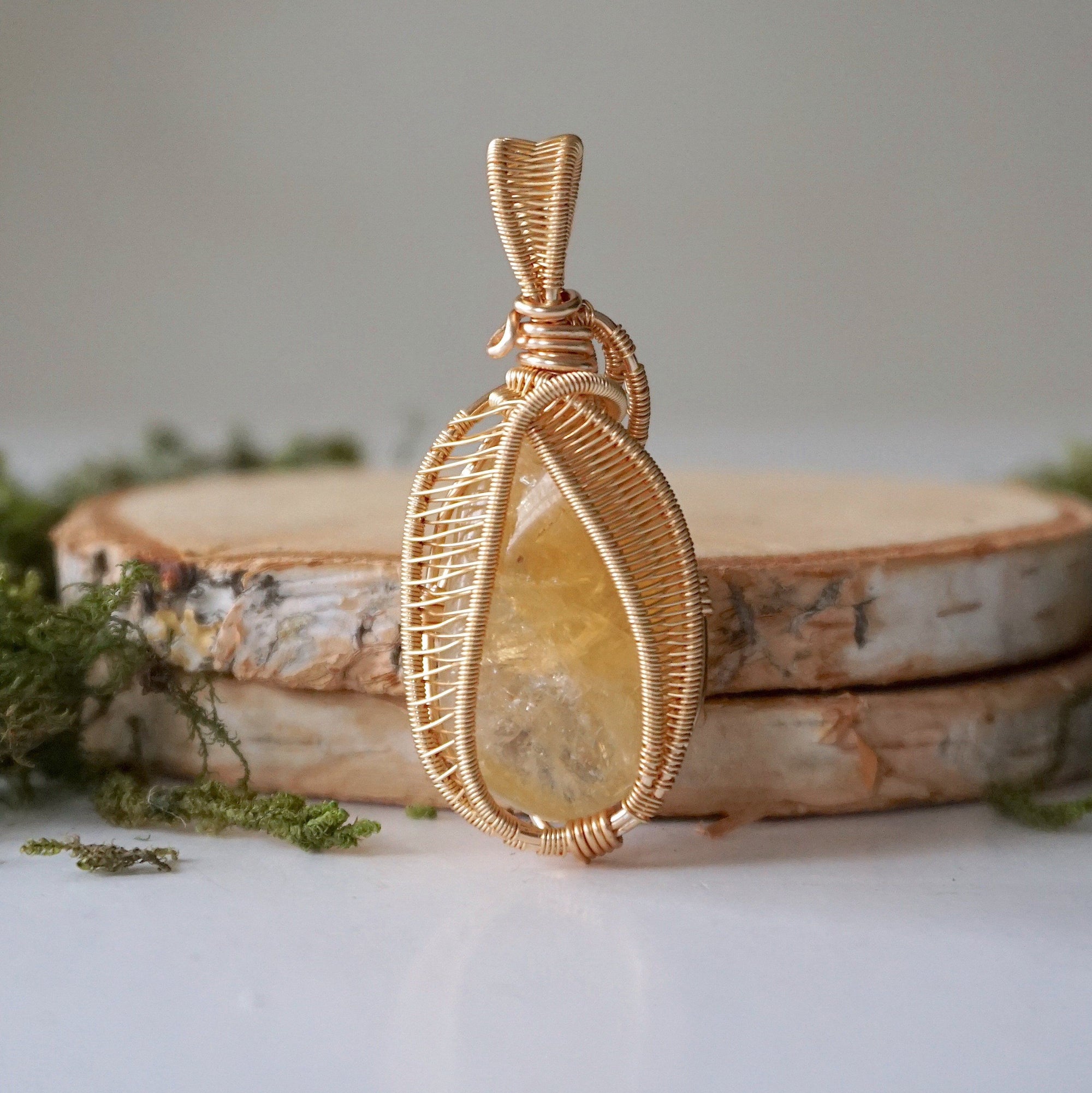 Close-up front view of polished citrine pendant gold wire wrapped November birthstone showing intricate detail
