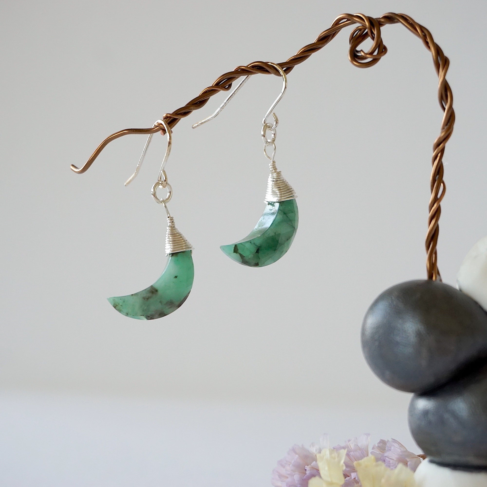 Front view of emerald moon drop earrings in 925 sterling silver with natural faceted crescent moon emeralds.
