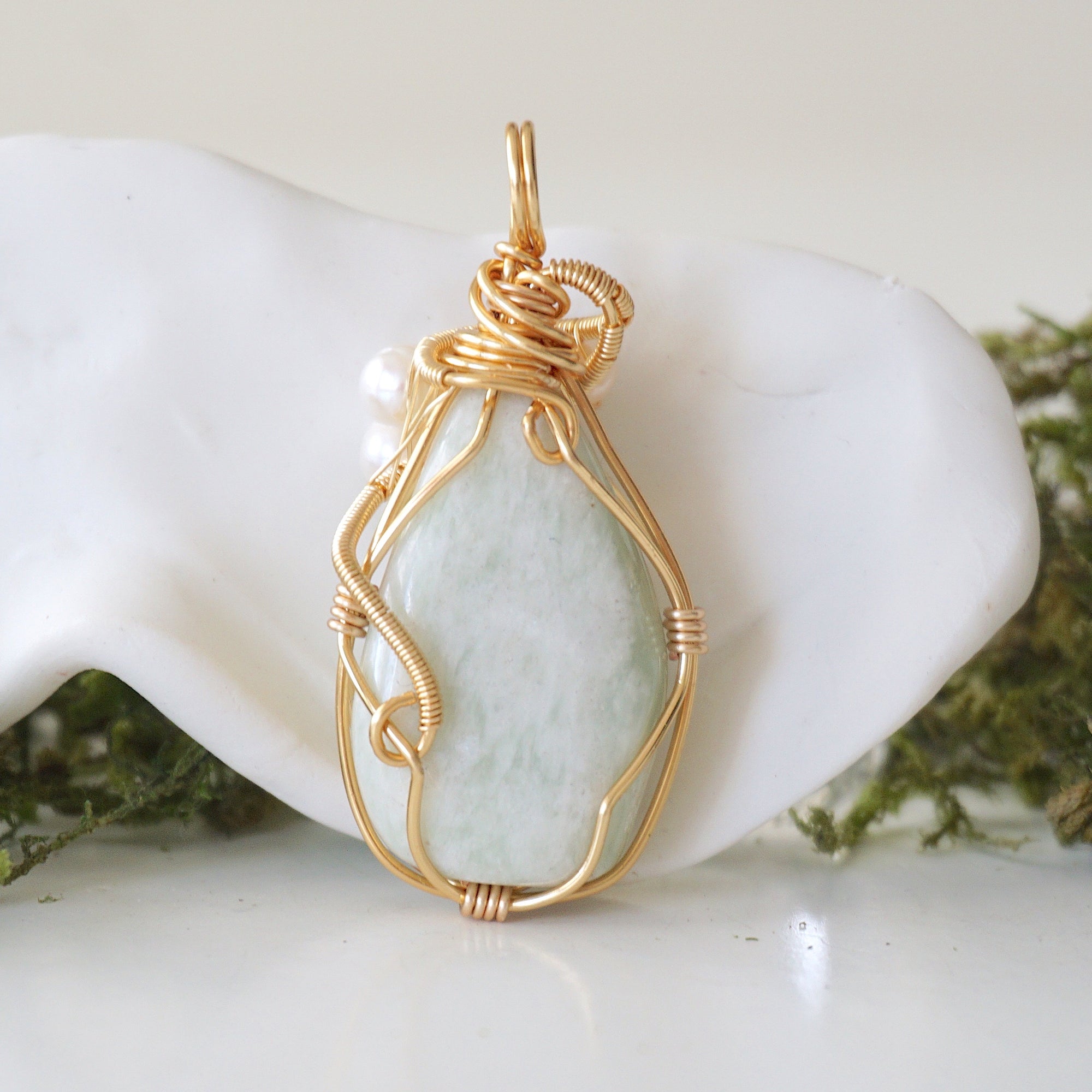Back angle detail of jade and freshwater pearl pendant, showing wire wrapping and natural stone