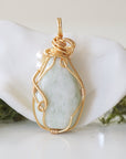 Back angle detail of jade and freshwater pearl pendant, showing wire wrapping and natural stone