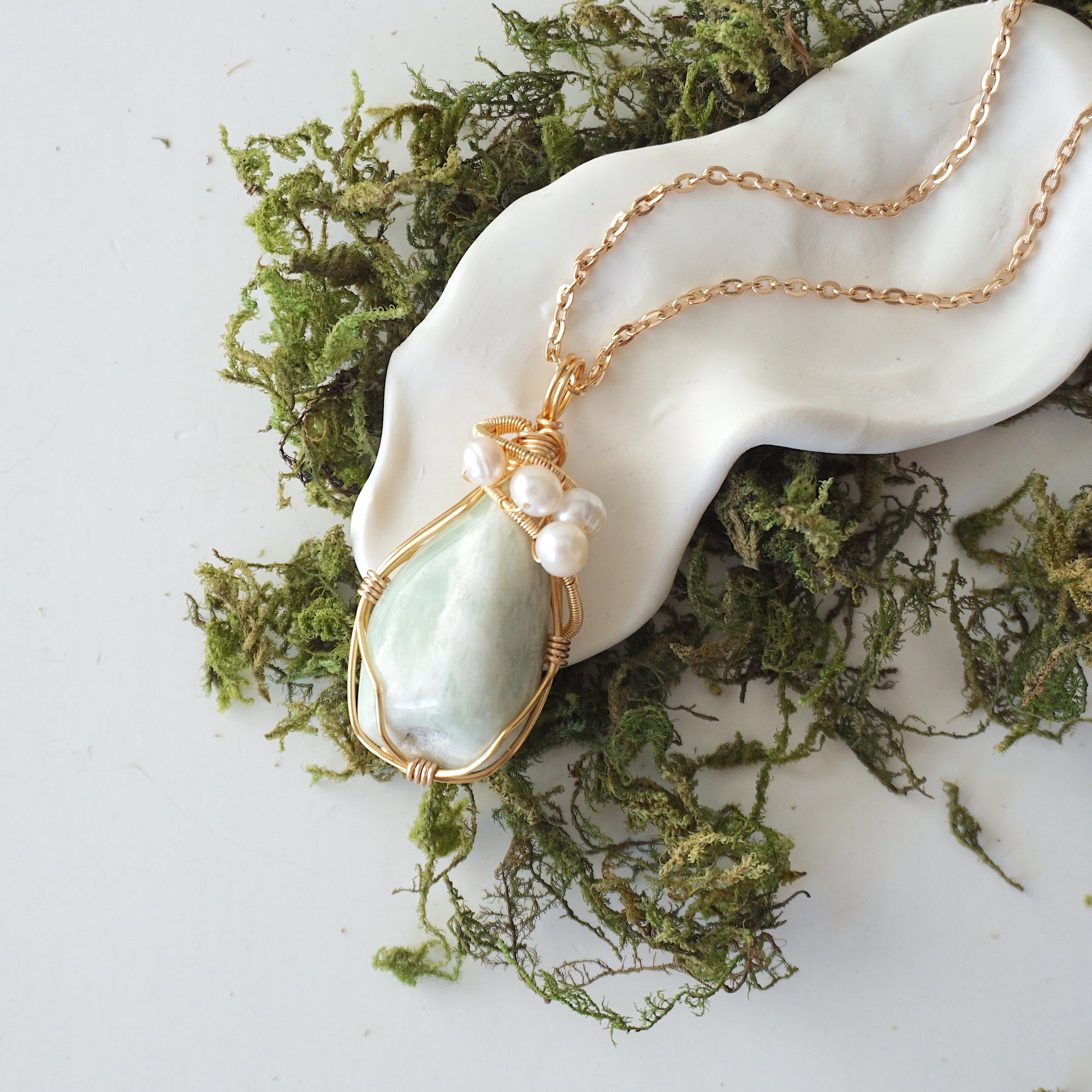 Jade and freshwater pearl pendant on gold plated brass chain laying flat, handmade wire wrapped jewelry for women