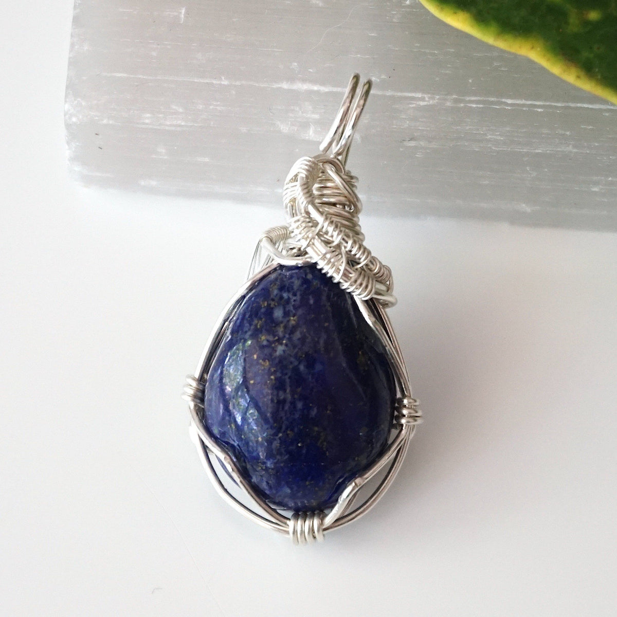 Back of a lapis lazuli pendant showing the hand wire-wrapped sterling silver pattern