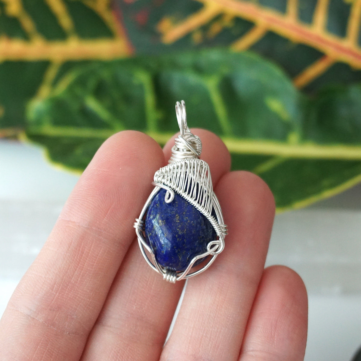 Lapis lazuli sterling silver pendant held in the hand to show its size