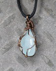 Back side angle of men's aquamarine pendant necklace, detailed wire wrapping, antique bronze copper, black leather cord