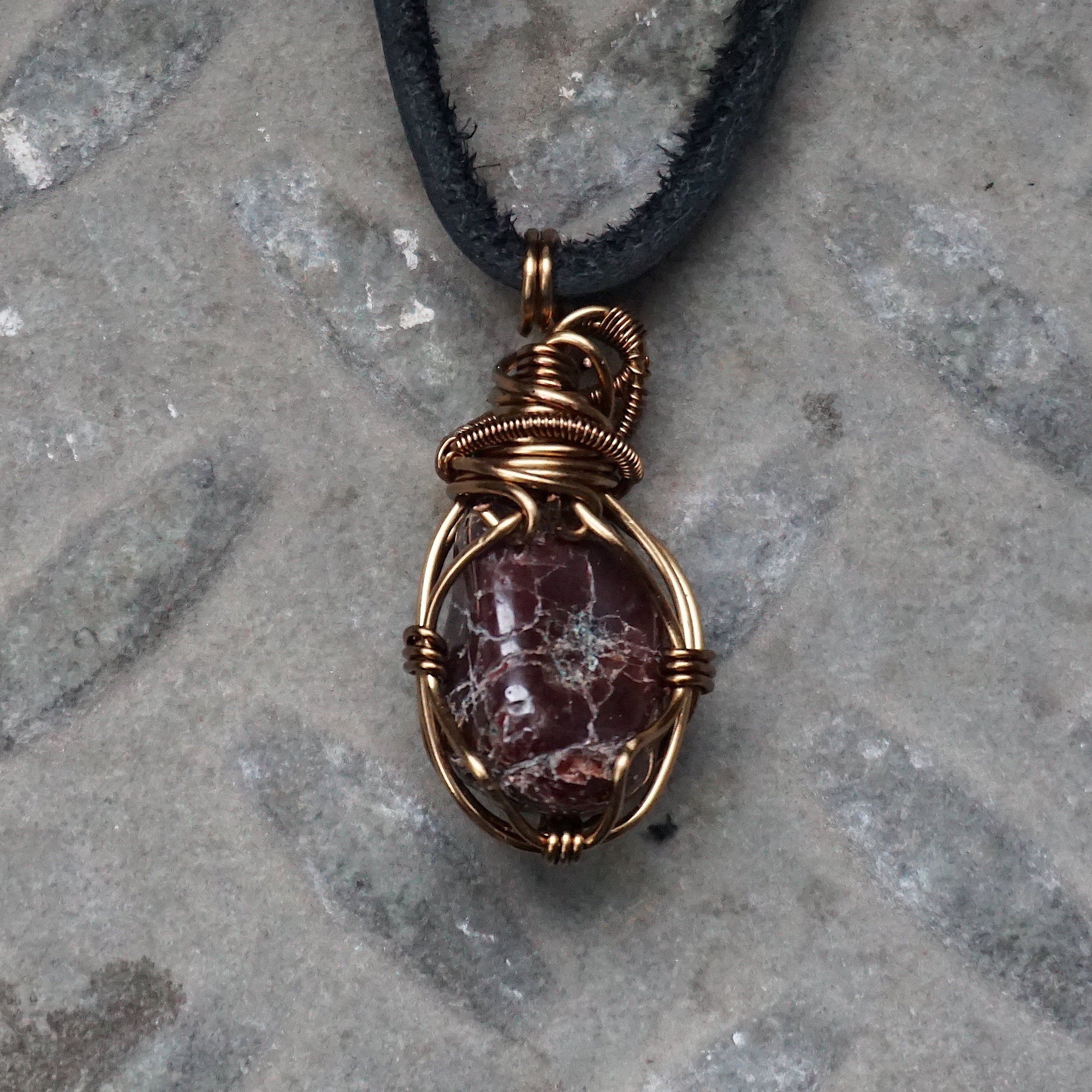 Back view of a men’s garnet wire wrapped pendant necklace in antique bronze copper, highlighting the handcrafted wire work