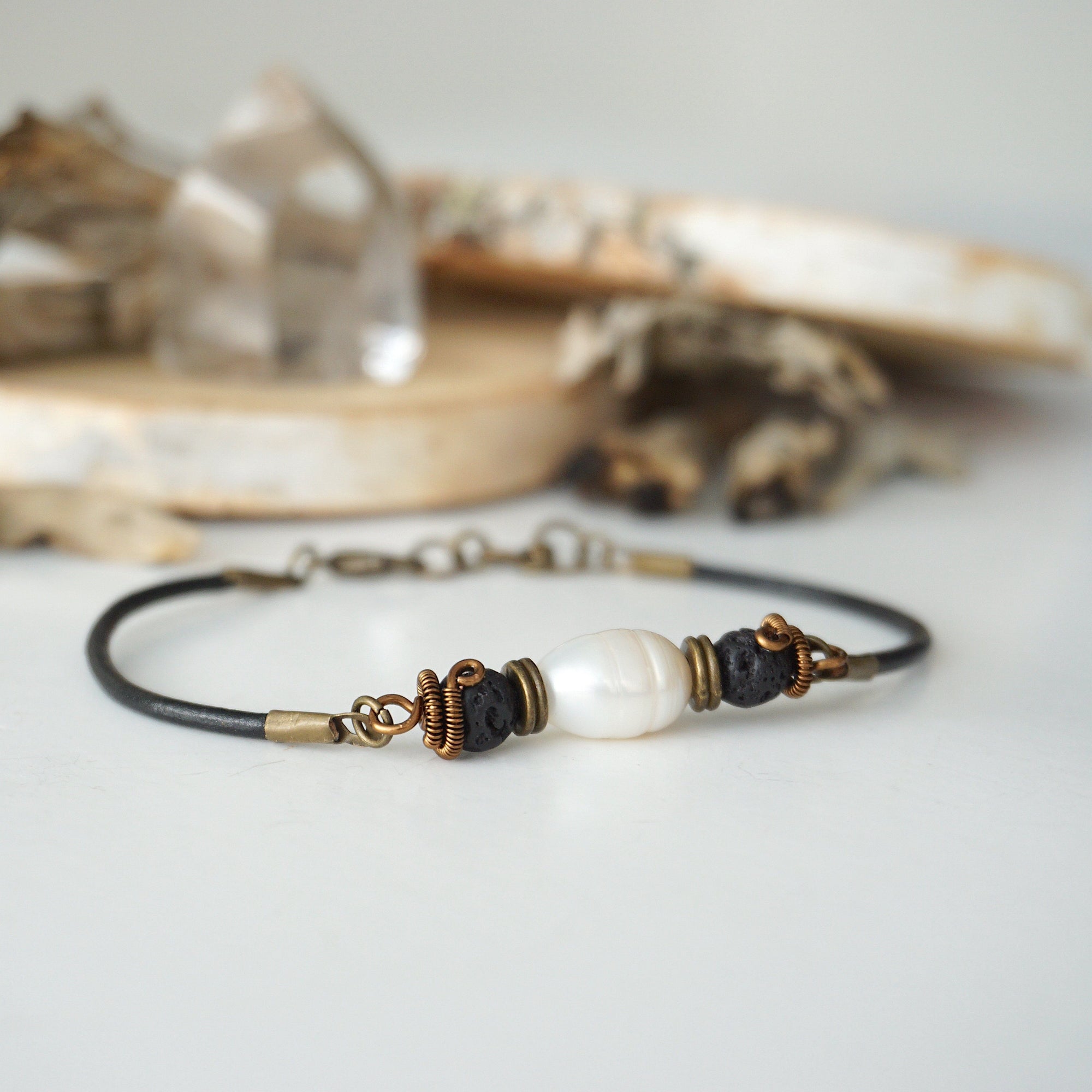 Close-up view of a men’s pearl leather bracelet featuring a natural freshwater pearl and lava stone beads