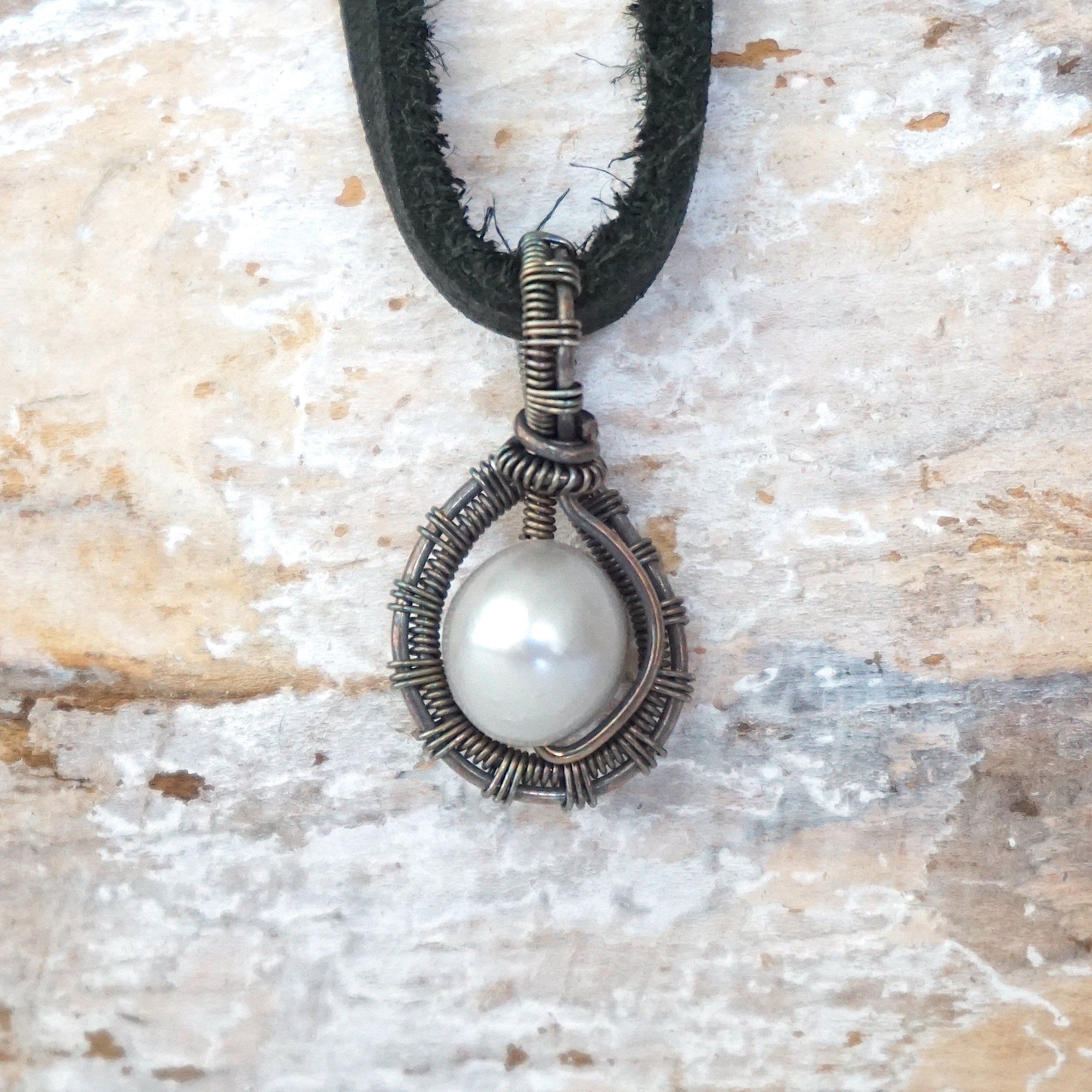 Back angle view of a men’s pearl pendant necklace showing the handcrafted antiqued sterling silver wire wrap