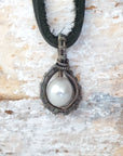 Back angle view of a men’s pearl pendant necklace showing the handcrafted antiqued sterling silver wire wrap