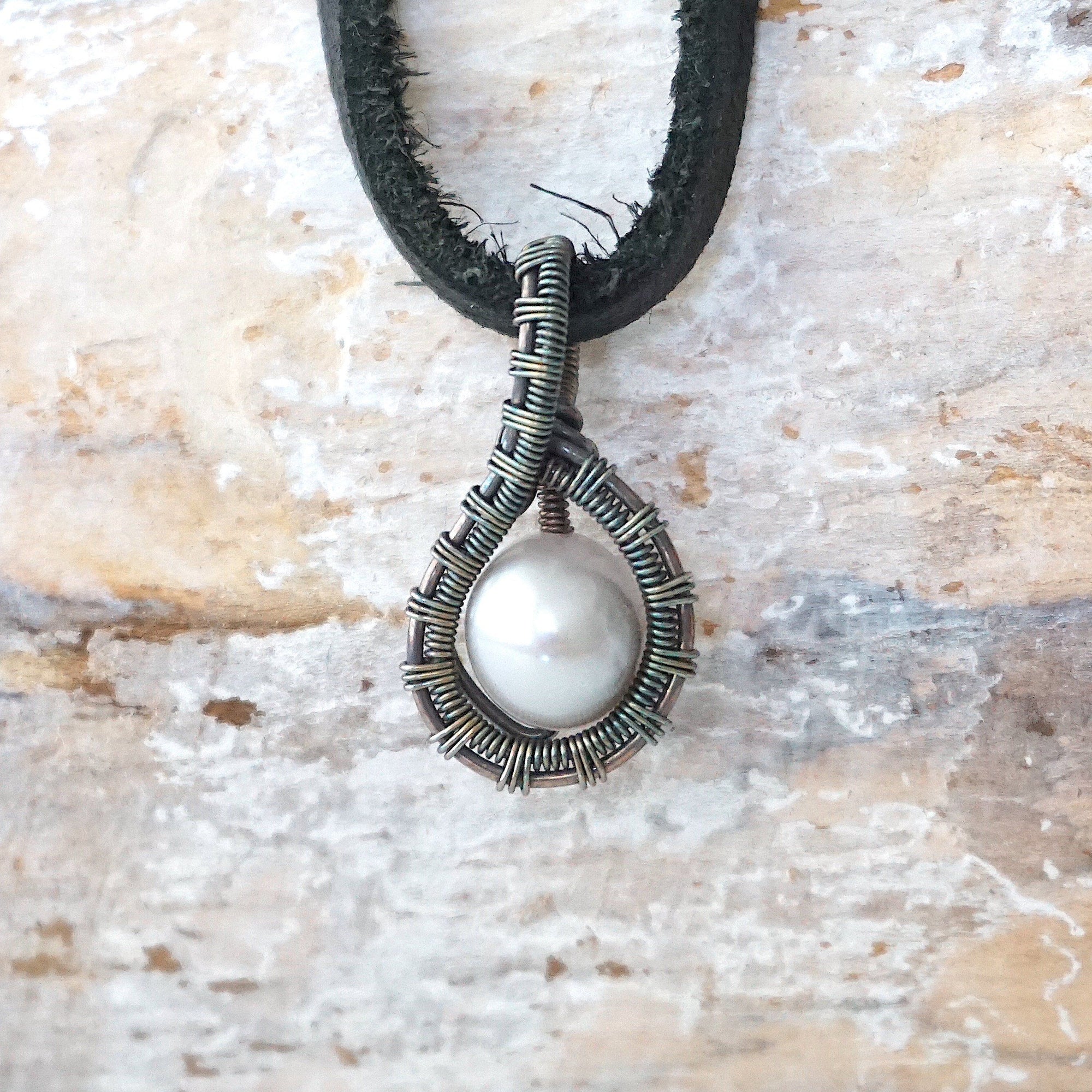 Men’s pearl pendant necklace with a natural freshwater pearl on a black leather cord, shown in full view