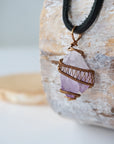 Left side view of men’s raw amethyst pendant in antique bronze copper wire wrap on black leather cord, natural crystal necklace