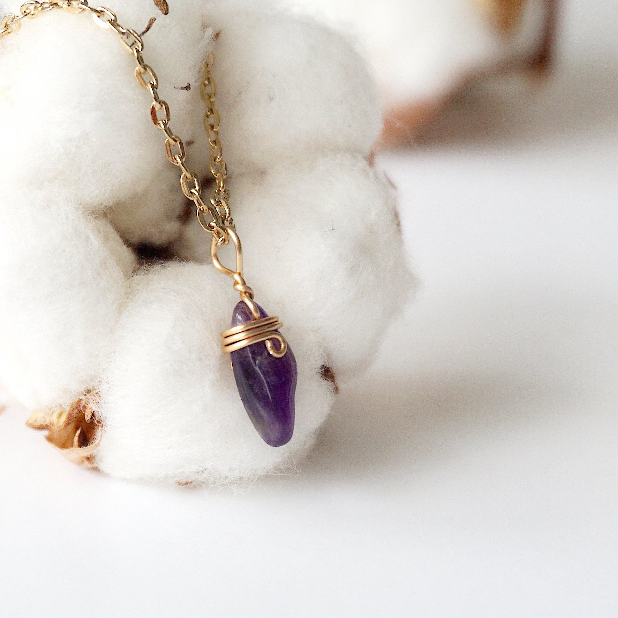 Right side angle of minimalist amethyst necklace, raw amethyst pendant wire wrapped in gold plated copper