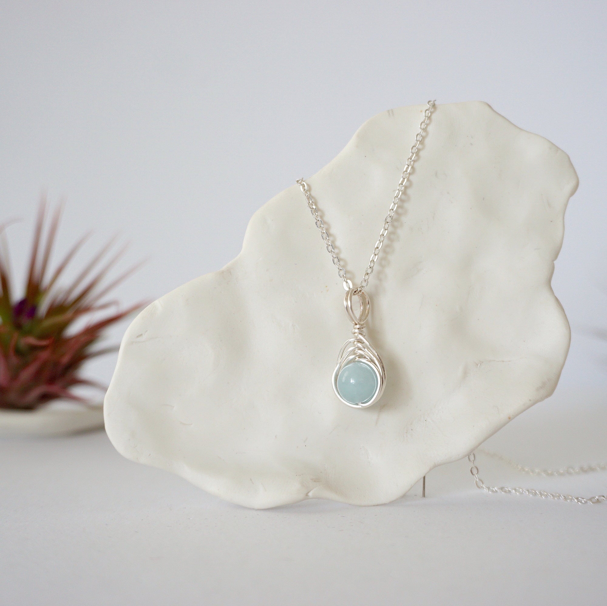 Minimalist aquamarine necklace hanging on display, detailed front view, genuine 8mm aquamarine bead, soft silver finish wire, Designs by Nature Gems