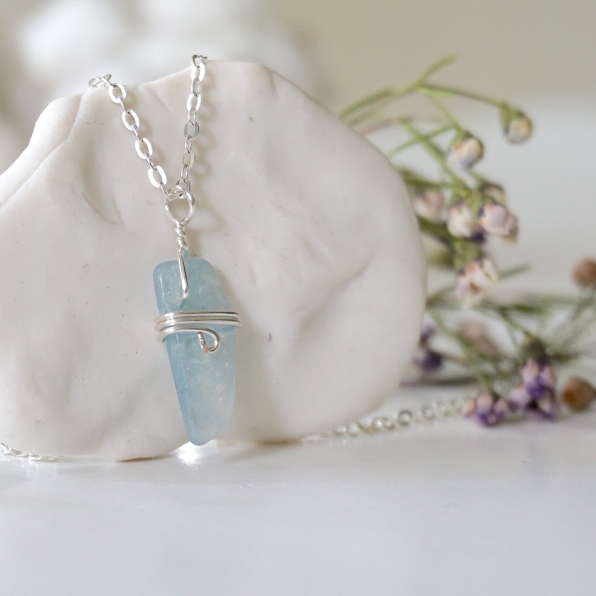 Right side angle of minimalist aquamarine necklace, showing genuine aquamarine pendant and soft silver finish over copper wire