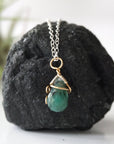 Back angle detail of minimalist emerald pendant necklace for women with natural faceted emerald and handcrafted mixed metal wrapping