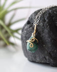 Left angle detail of emerald necklace for women with natural faceted teardrop emerald and artisan mixed metal wire wrapping