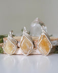 Three natural citrine crystals showing variation in color size and shape - pale yellow to golden amber unique wire wrapped silver plated pendants one of a kind