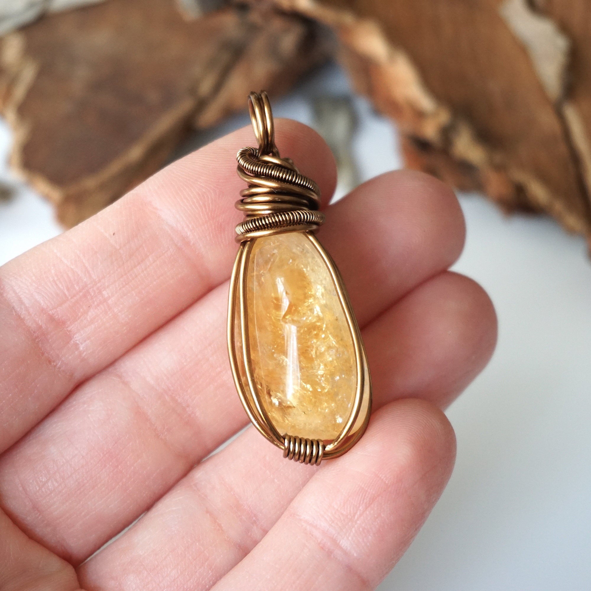Natural citrine pendant held in hand showing size scale - wire wrapped crystal in antique bronze copper handmade unisex necklace size reference for women men