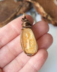 Natural citrine pendant held in hand showing size scale - wire wrapped crystal in antique bronze copper handmade unisex necklace size reference for women men