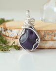 Back view detail of polished dark amethyst pendant necklace with silver plated copper wire wrap