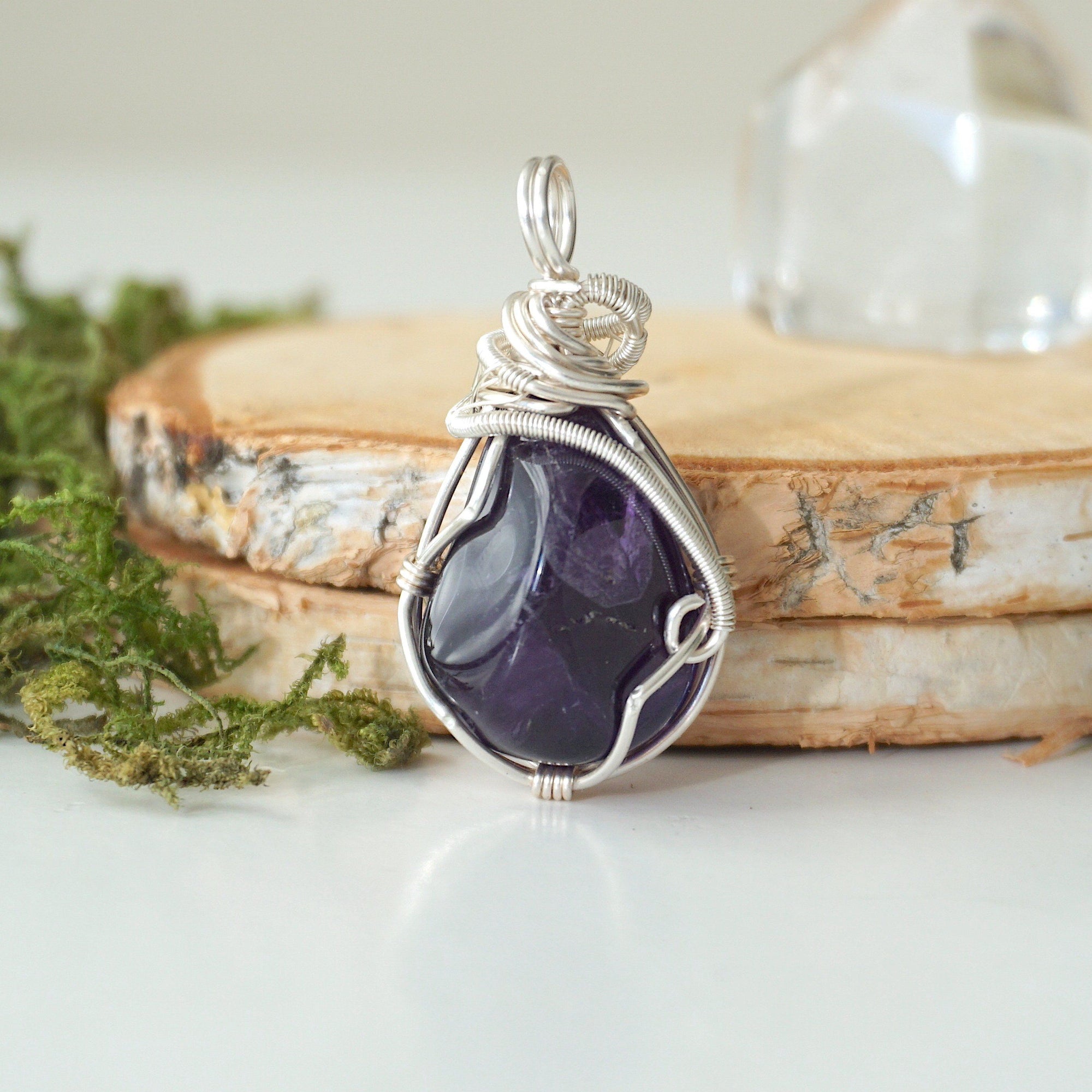 Back view detail of polished dark amethyst pendant necklace with sterling silver wire wrap