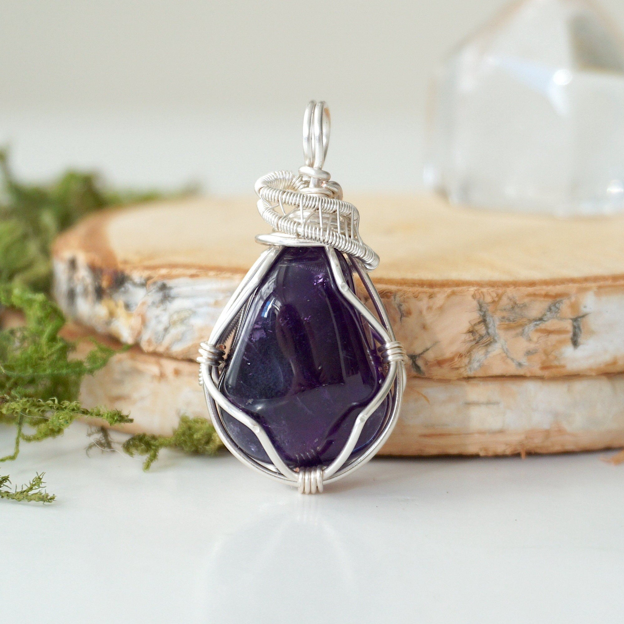 Front view of polished dark amethyst pendant necklace, detailed silver plated copper wire wrap