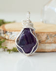 Front view of polished dark amethyst pendant necklace, detailed silver plated copper wire wrap
