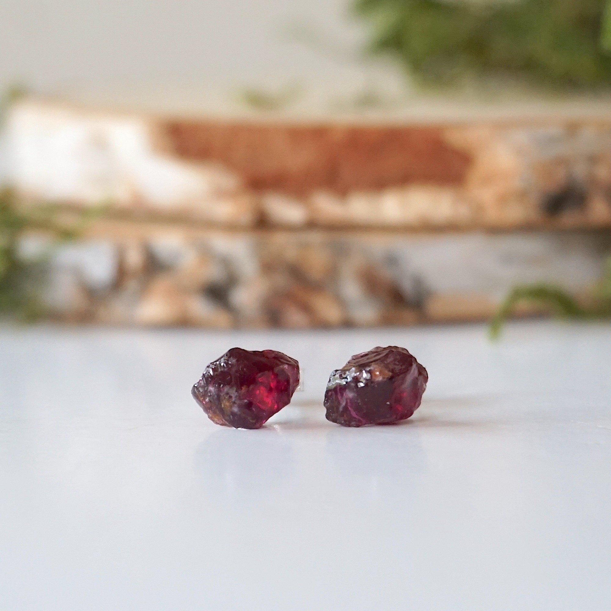Front detail of natural raw garnet stud earrings with 925 sterling silver posts, minimalist January birthstone earrings