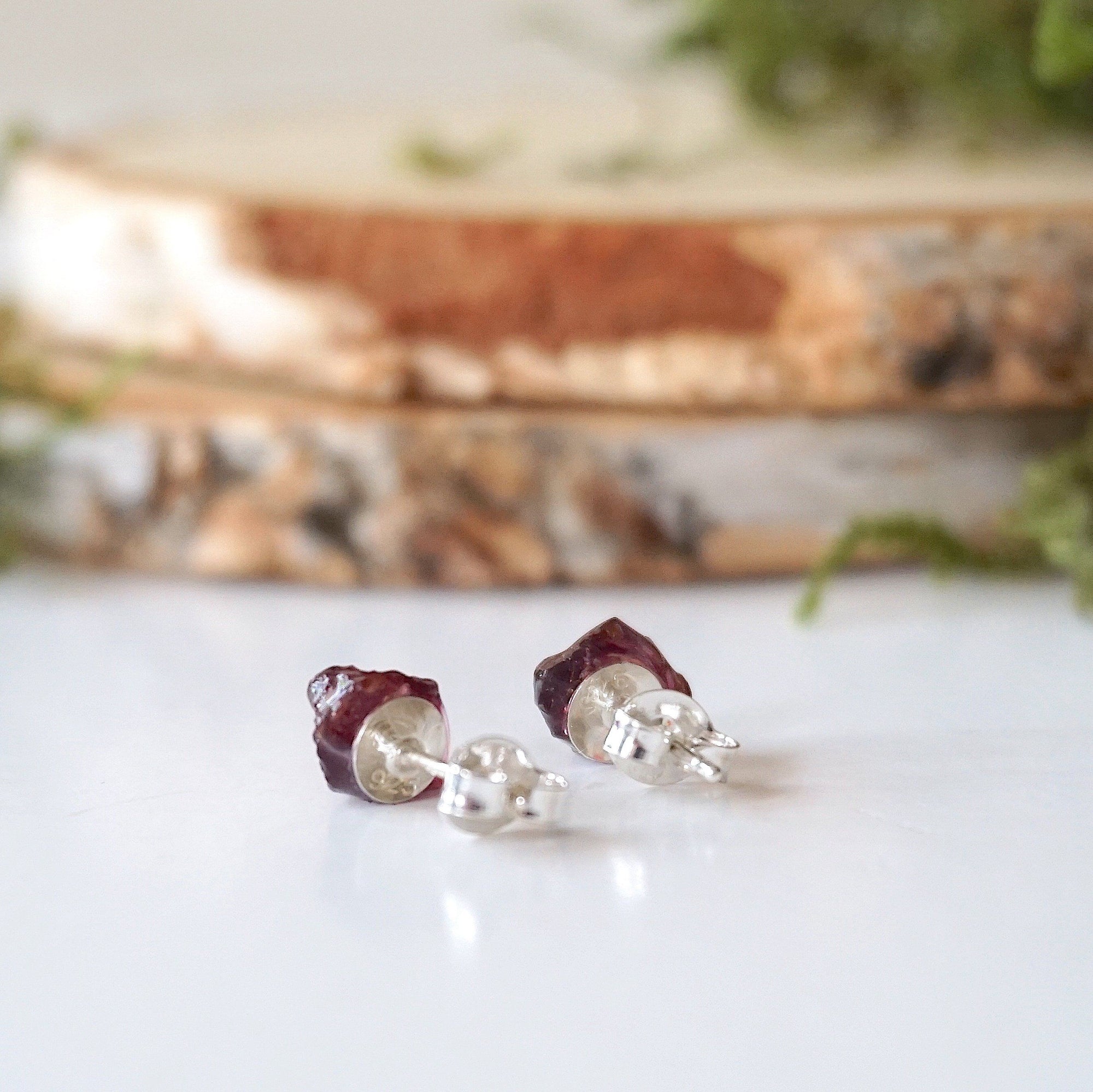 Back detail of garnet stud earrings showing 925 sterling silver posts and backs, hypoallergenic minimalist earrings