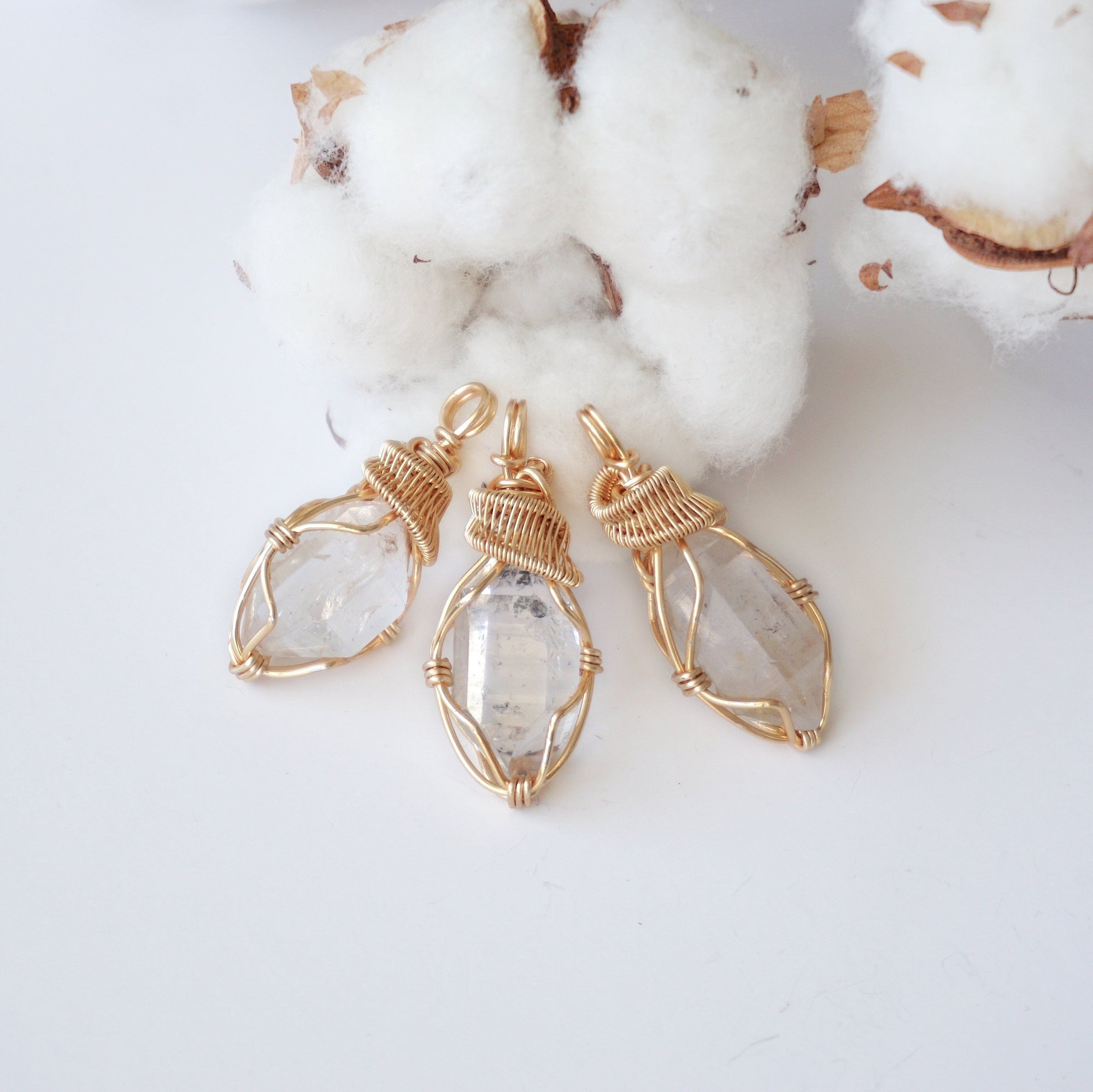 Three Herkimer diamond pendants showing natural variation in crystal size, shape, and handcrafted wire wrapping.