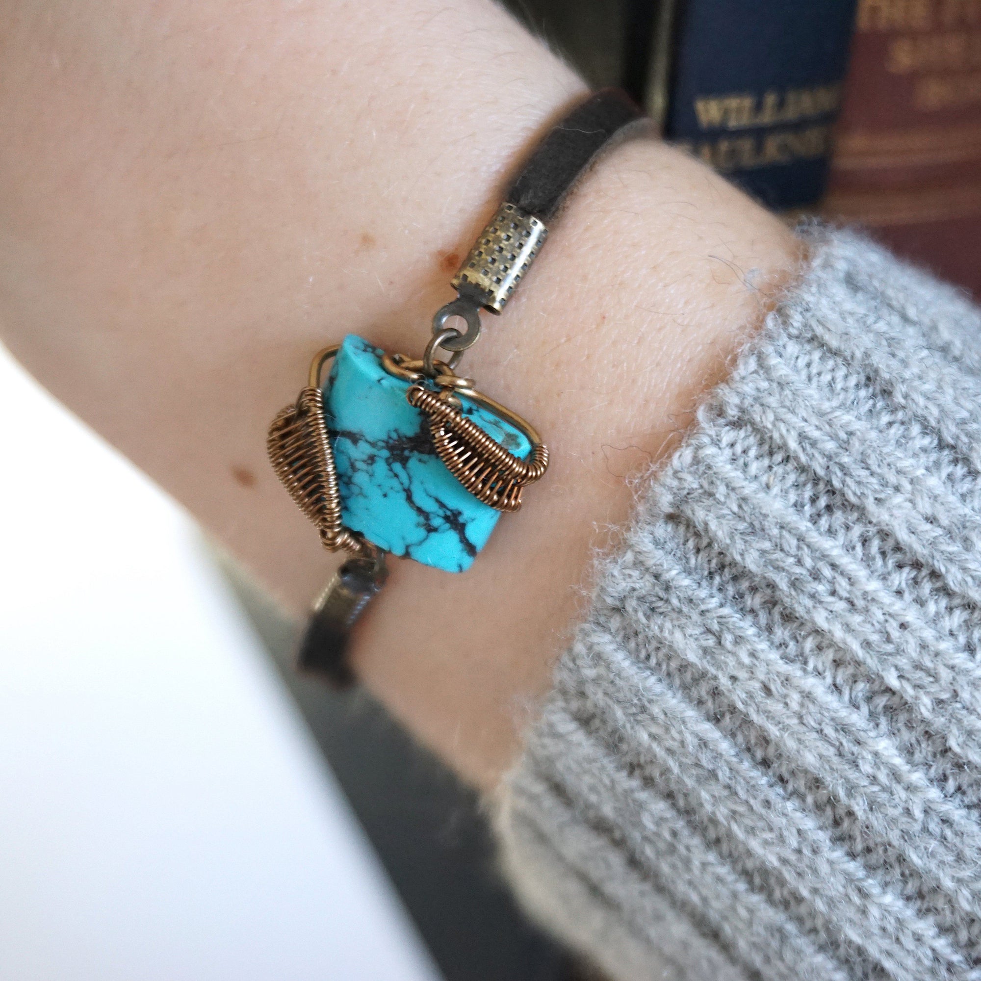 Natural turquoise bracelet with antique bronze wire wrapping on genuine leather strap worn by woman, December birthstone jewelry