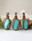 Three natural turquoise necklace pendants showing color and matrix pattern variations in authentic natural stones with bronze wire