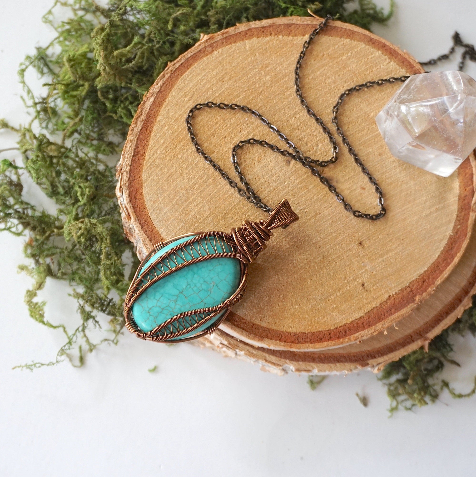 Natural turquoise necklace for women with intricate antique bronze wire wrapped pendant on 24 inch chain laying flat