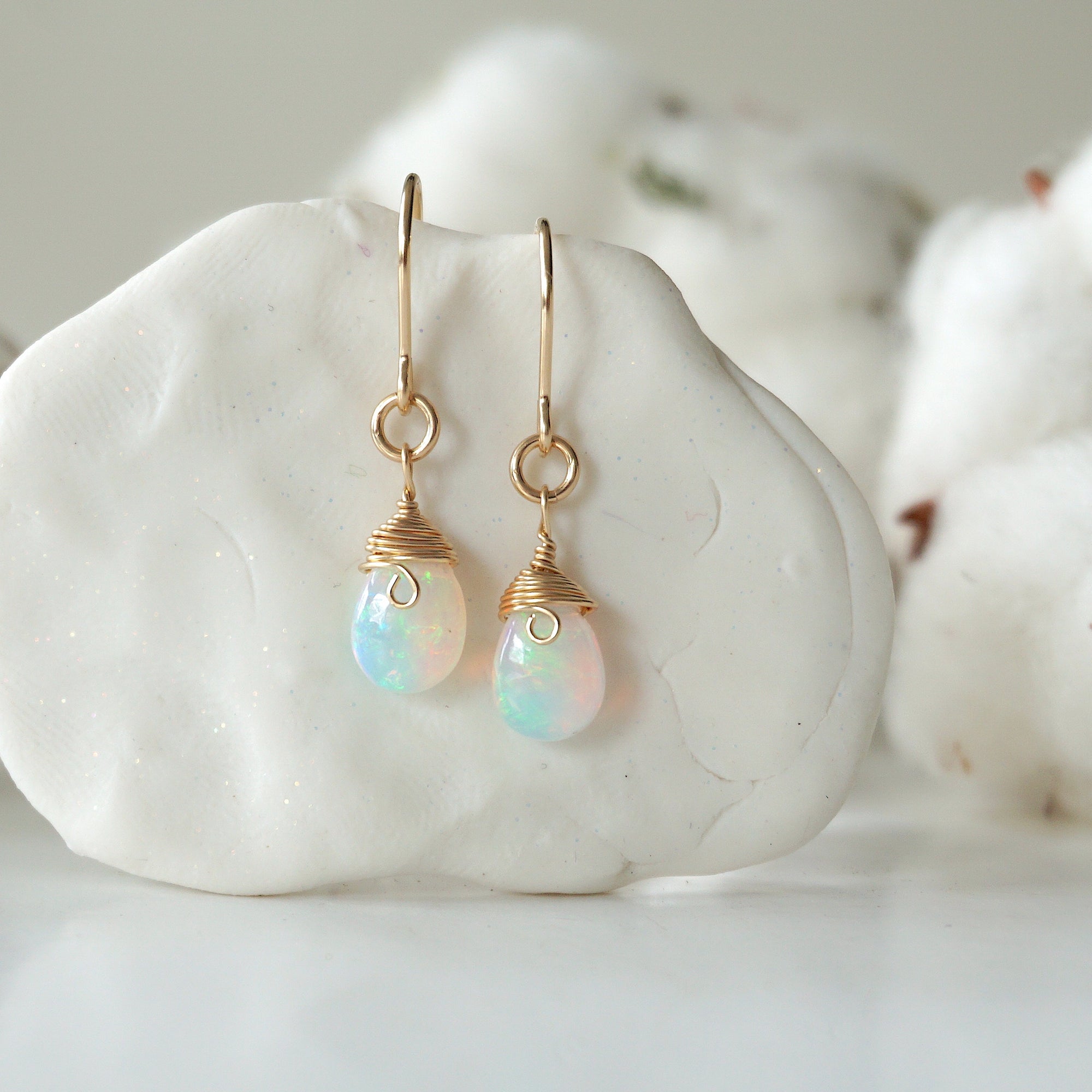 Detailed front view of opal drop earrings, natural faceted opal with minimalist 14k gold filled wire wrapping, Designs by Nature Gems