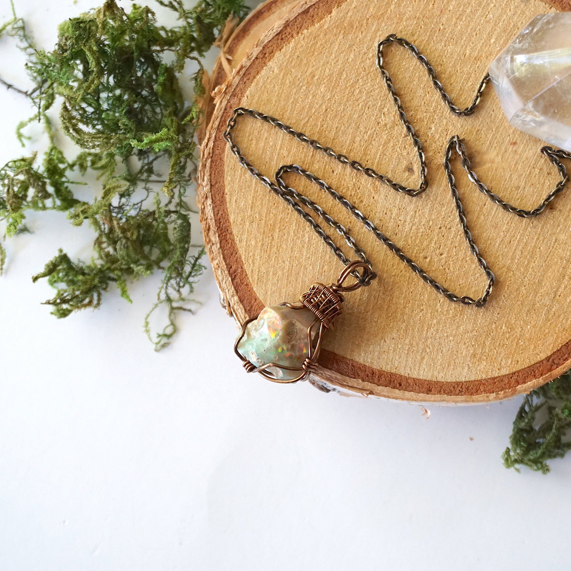 Natural opal pendant on antique bronze chain laying flat, handcrafted jewelry by Designs by Nature Gems.