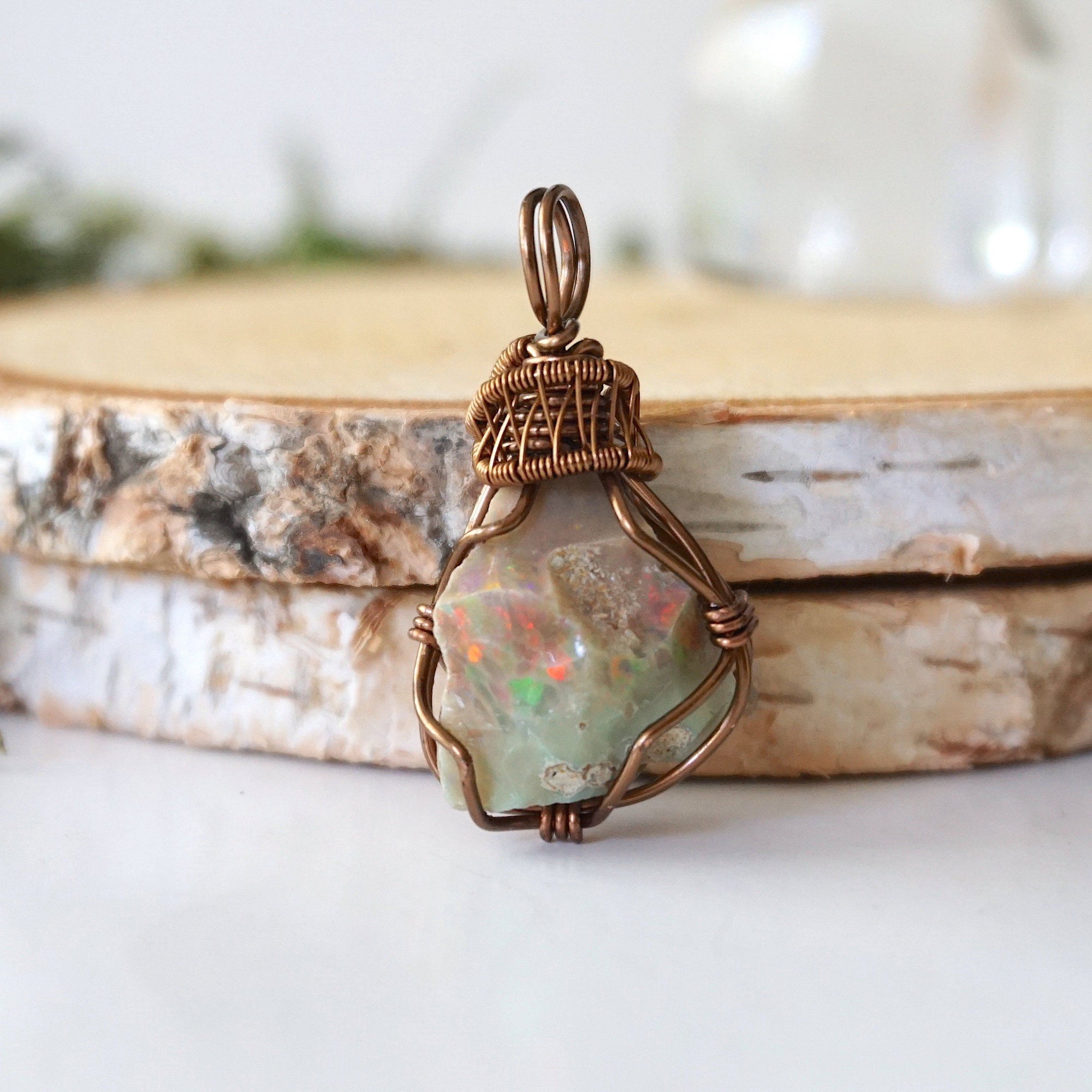 Detailed front view of natural opal pendant, artisan wire wrapped in antique bronze copper by Designs by Nature Gems.