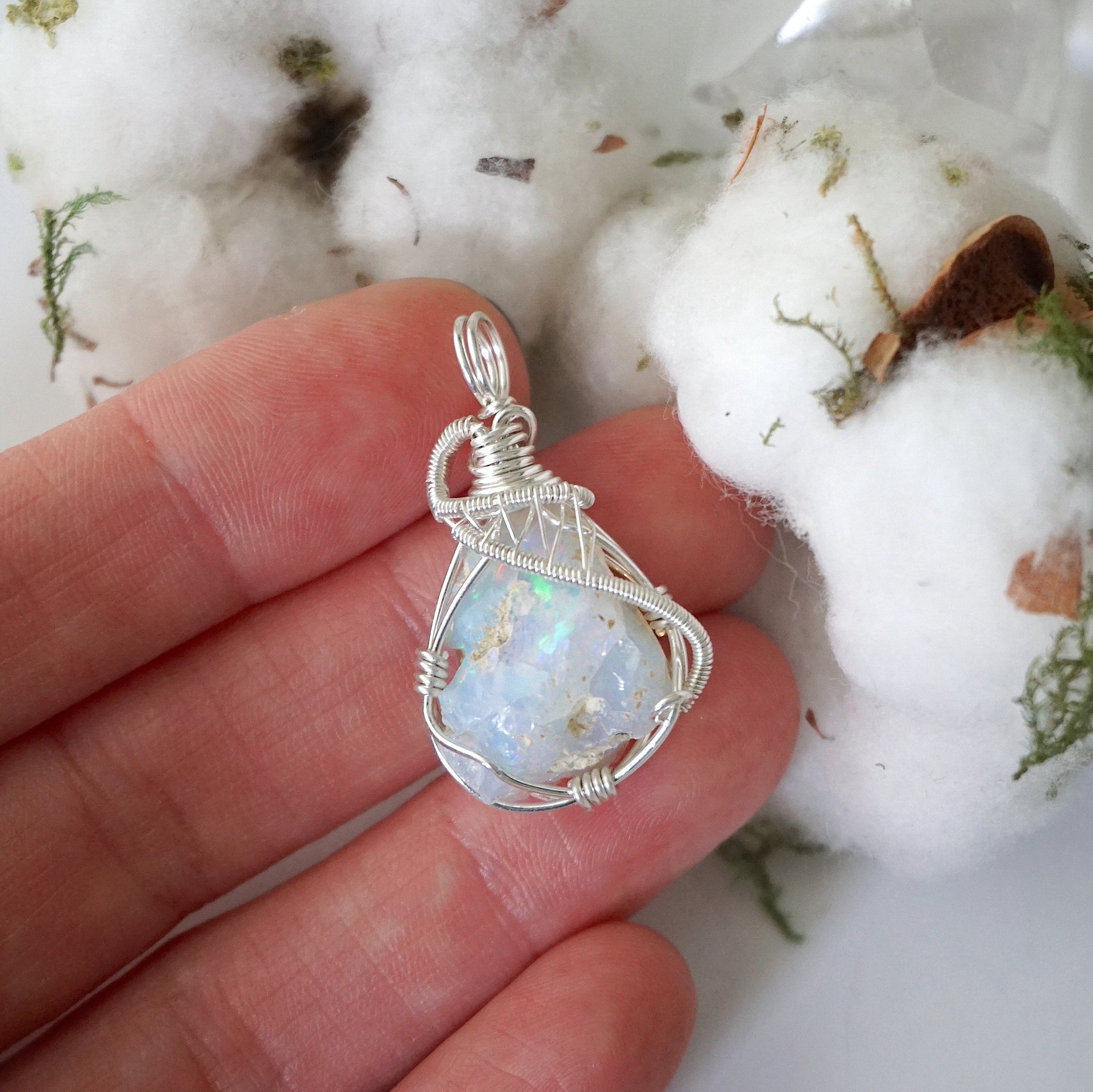 Sterling silver opal pendant in hand for size reference, handcrafted by Designs by Nature Gems.